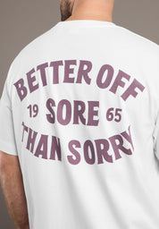 White t-shirt with purple text 'Better Off Sore Than Sorry' on the back, worn by a person.