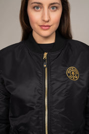 close up of woman in black golds gym bomber jacket
