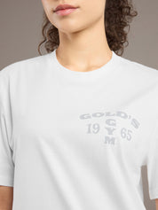 Person wearing a white t-shirt with 'Gold's Gym' logo