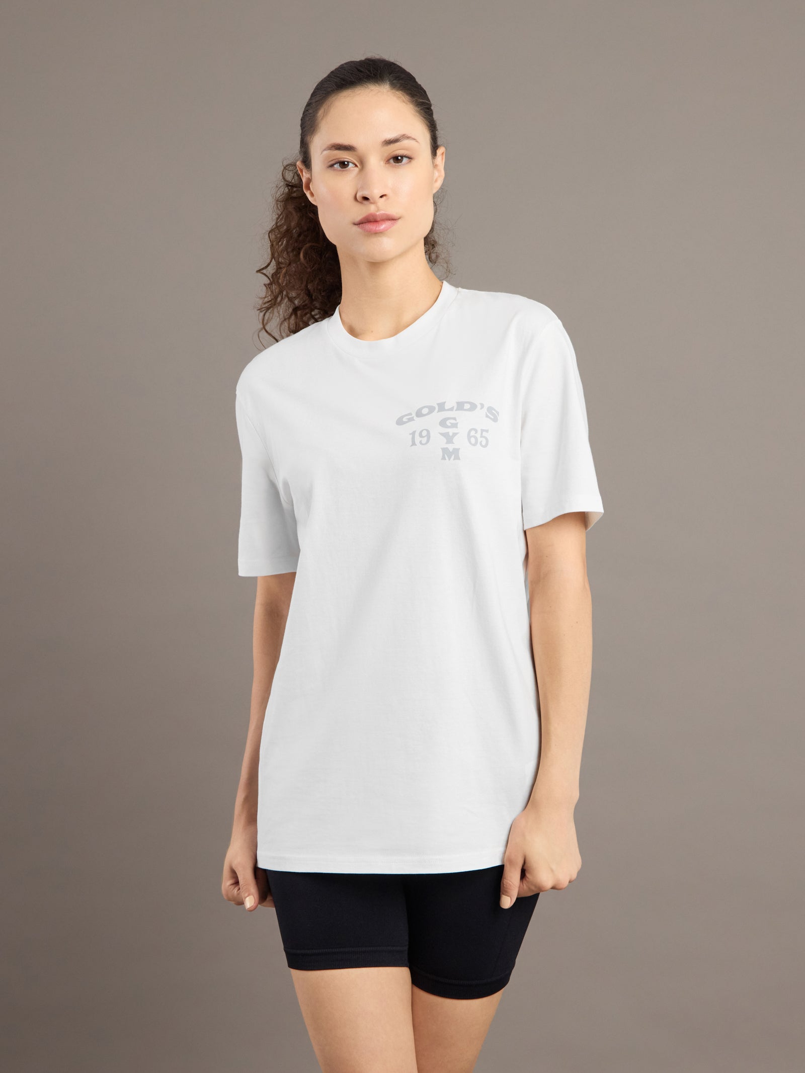 Woman wearing a white t-shirt with text on a brown background