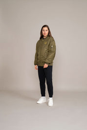 side view of woman in green golds gym logo jacket