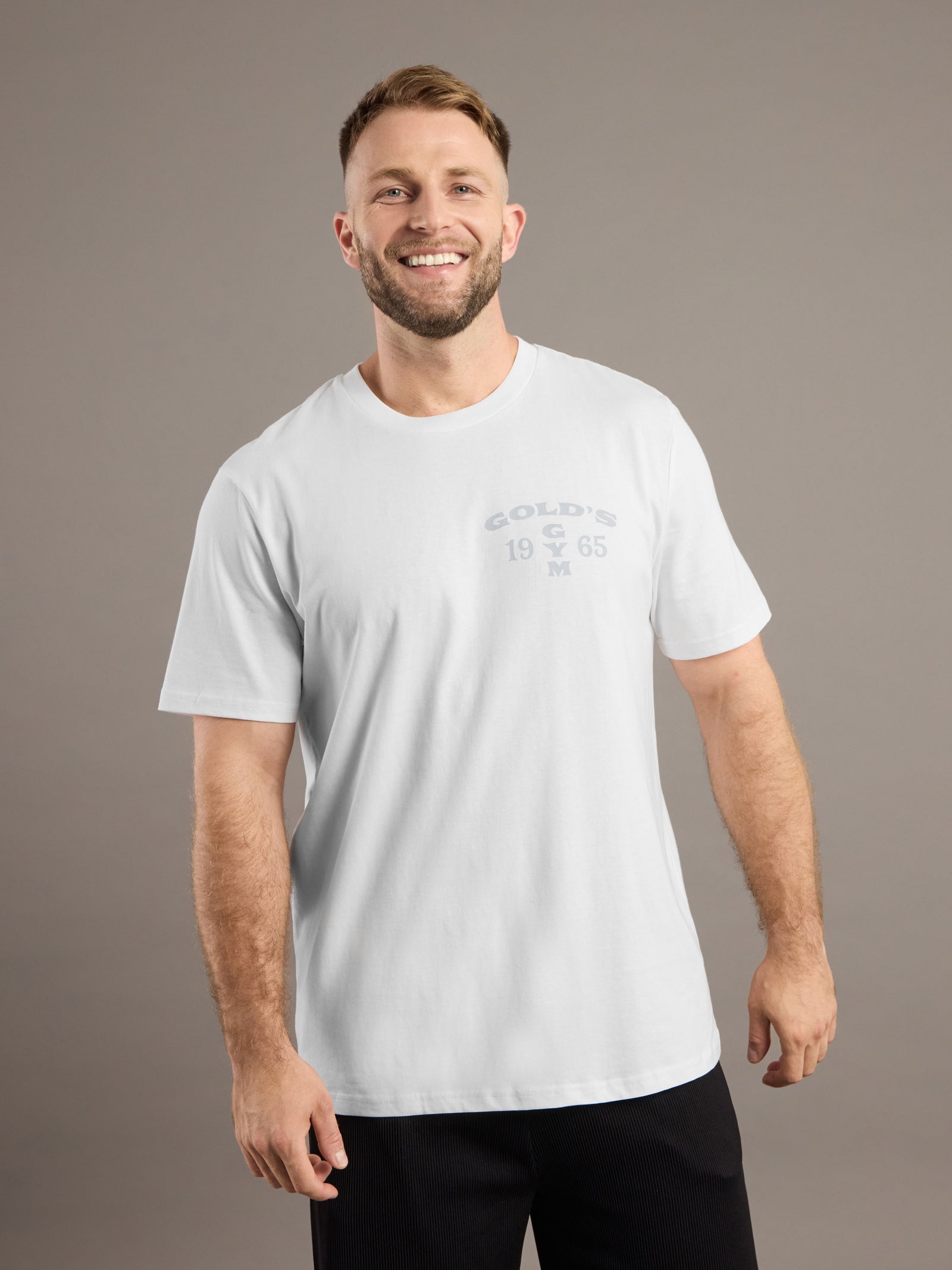 Man wearing a white t-shirt with text on a brown background