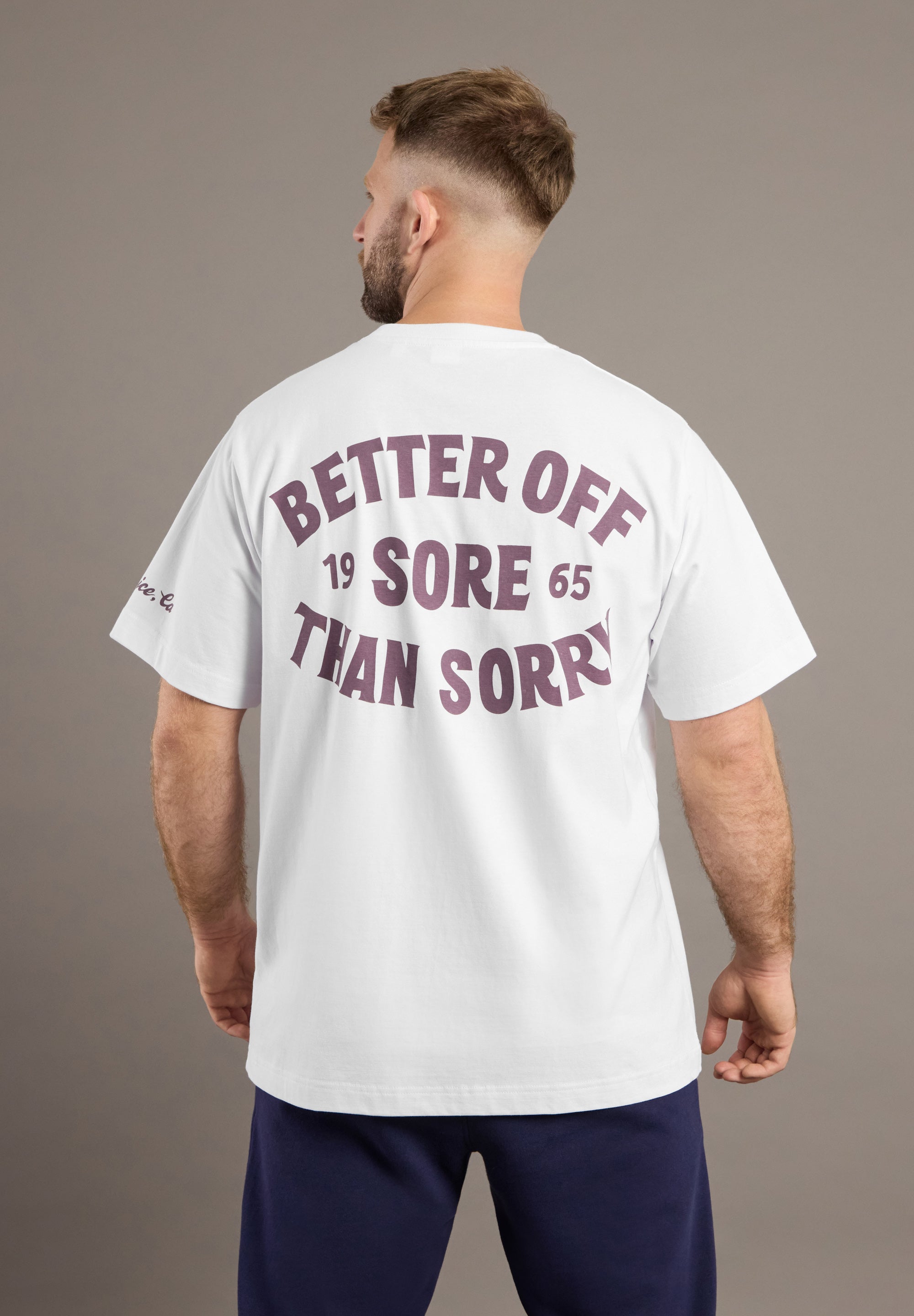 Man wearing a white t-shirt with text on the back against a gray background