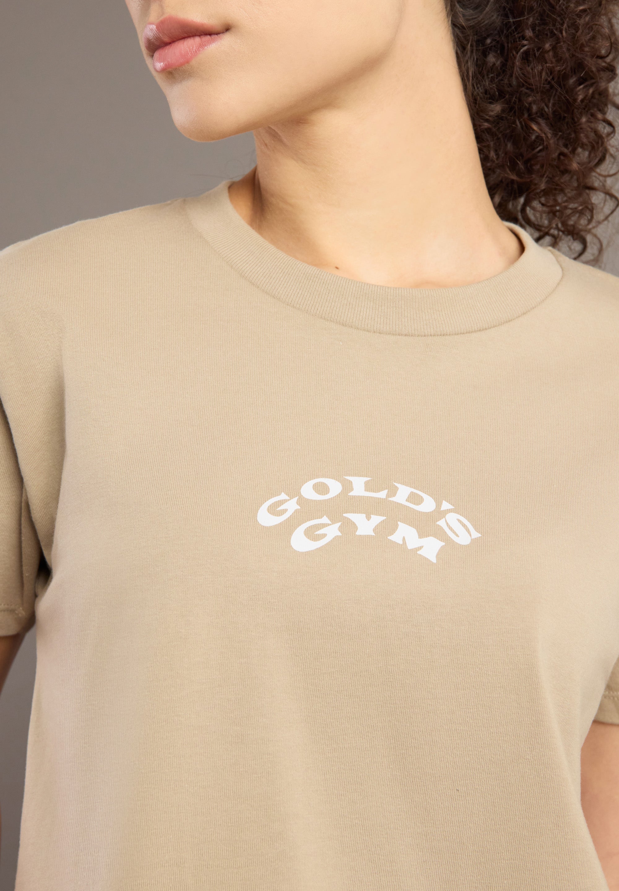 Beige t-shirt with Gold's Gym logo worn by a person
