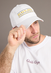 Man wearing a white cap with 'Gold's Gym' logo and matching t-shirt on a gray background