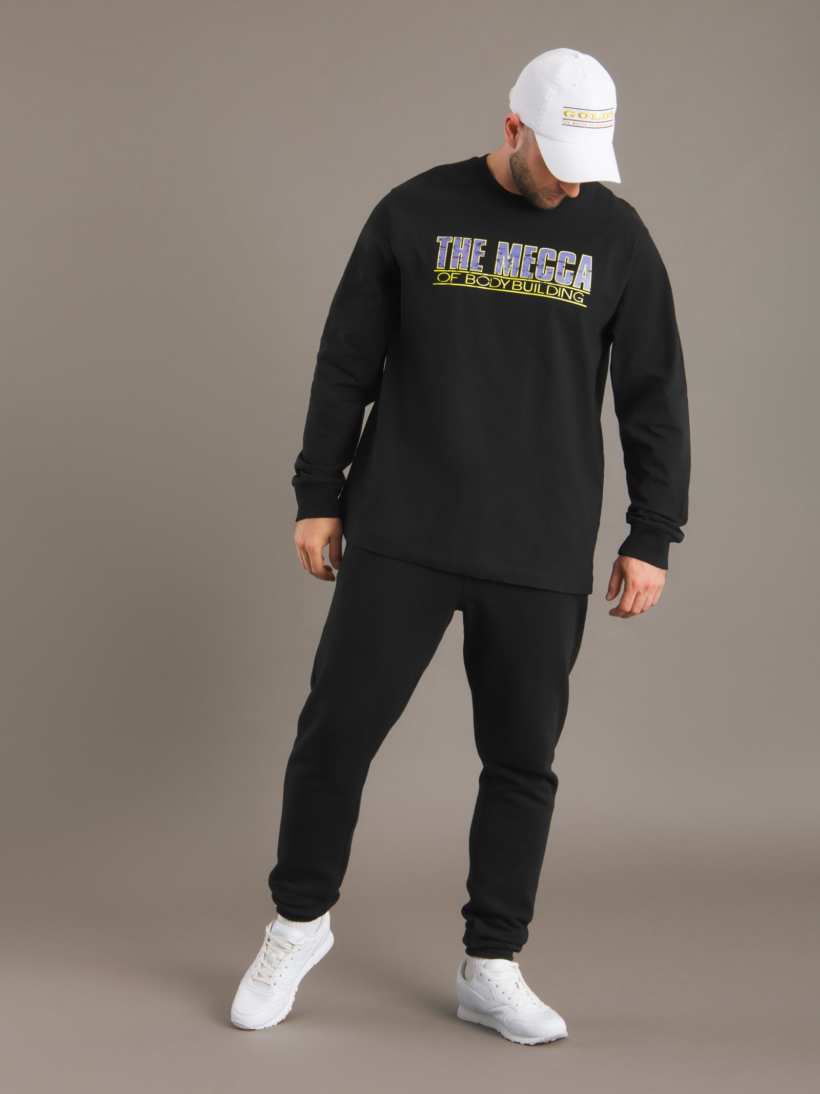 Person wearing a black sweatshirt with 'The Heeza' logo on a brown background