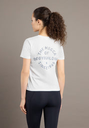 Woman wearing a white t-shirt with text on the back against a brown background