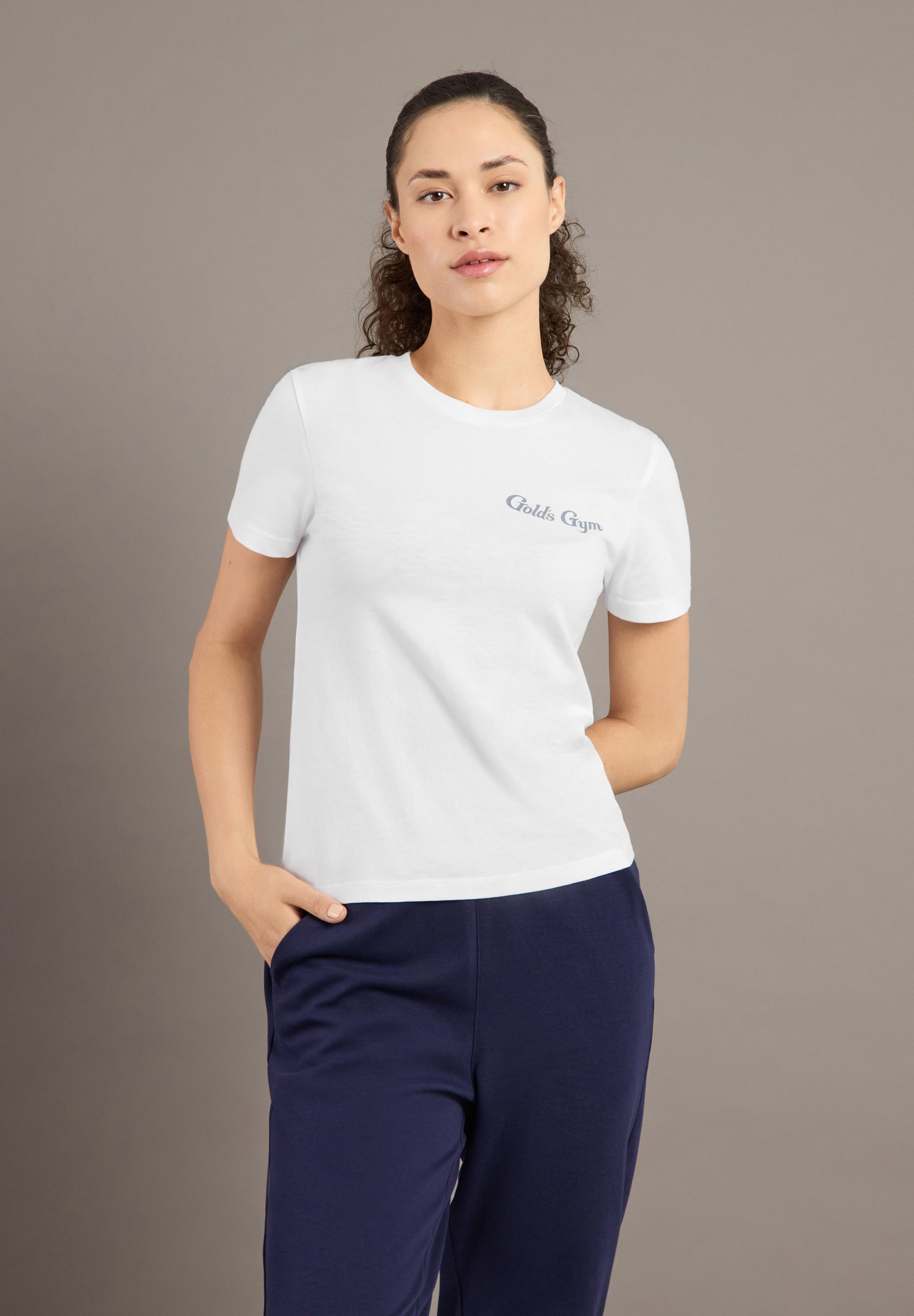 Woman wearing a white t-shirt with a logo on a brown background